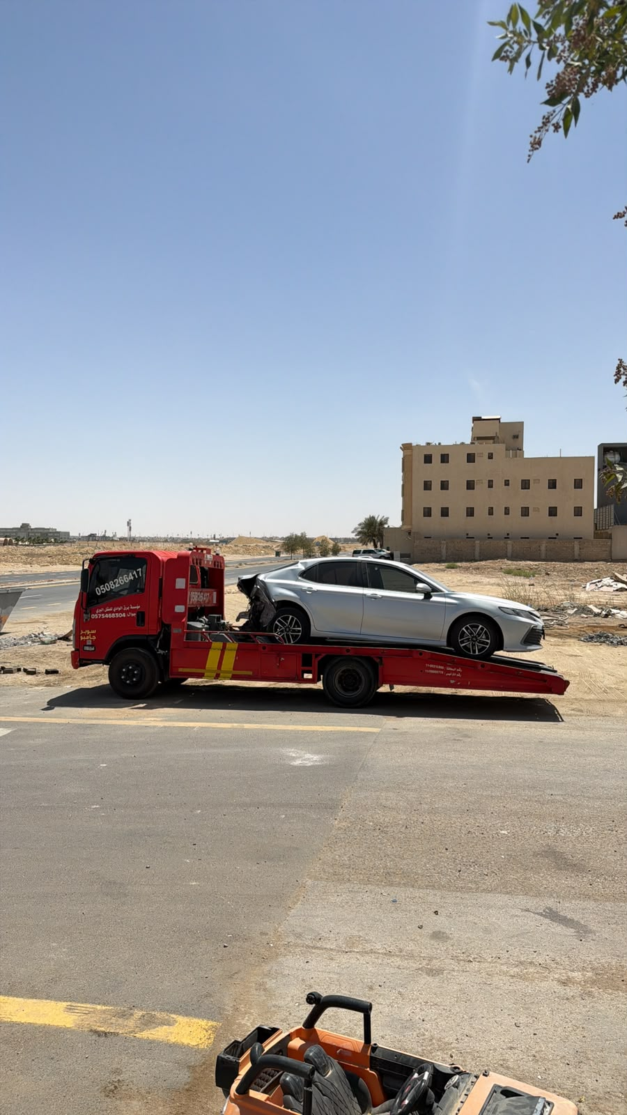 سطحة هيدروليك حمراء تنقل سيارة BMW فاخرة في الخرج